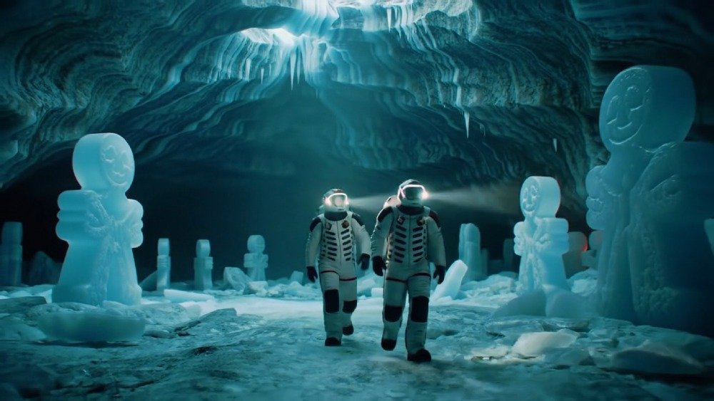 Frame do vídeo com Veo 2 mostra dois astronautas em um mundo gelado com doces gigantes